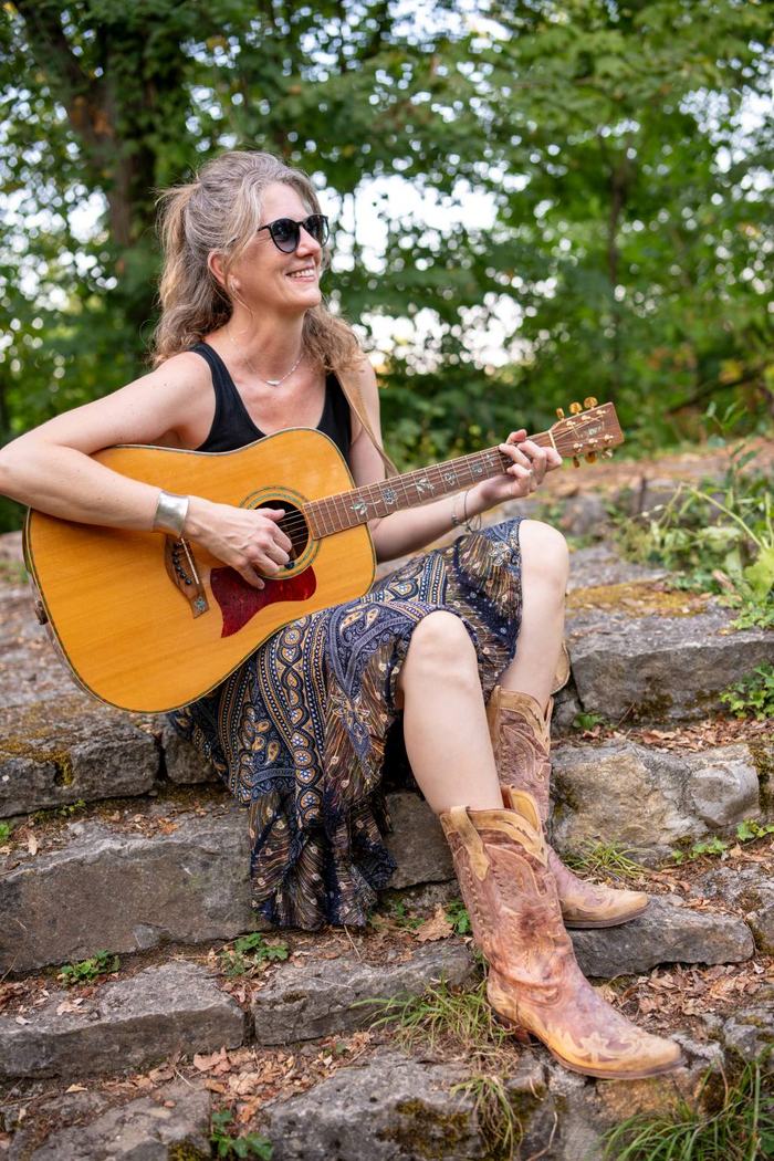 Birgit von Free Range Chicks mit Gitarre auf Steinstufen